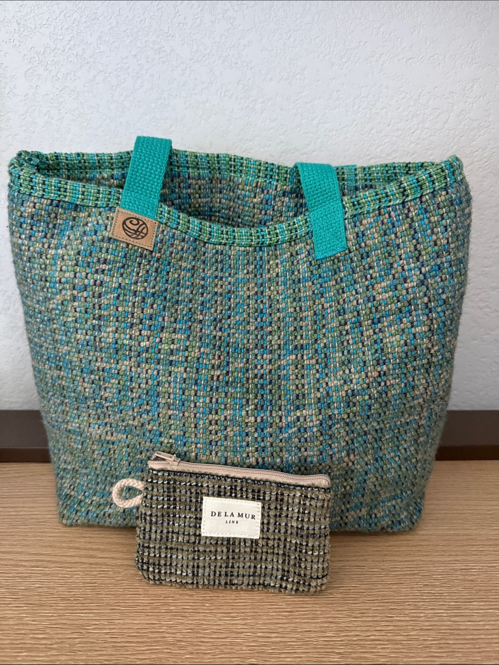 This is a hand-woven or loom-woven textile tote bag with matching coin pouch.